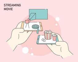 A hand holding a mobile phone and movie objects on a mobile screen. vector