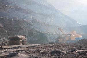 open cast mine dump trucks drive alone industrial area of iron ore quarry photo