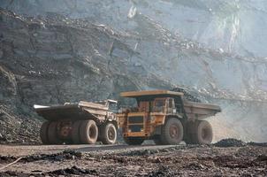 open cast mine dump trucks drive alone industrial area of iron ore quarry photo