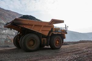 open cast mine dump trucks drive alone industrial area of iron ore quarry photo