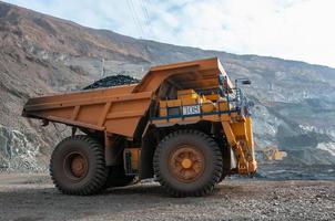 open cast mine dump trucks drive alone industrial area of iron ore quarry photo