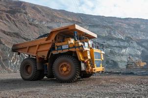 open cast mine dump trucks drive alone industrial area of iron ore quarry photo