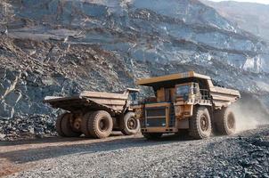 open cast mine dump trucks drive alone industrial area of iron ore quarry photo