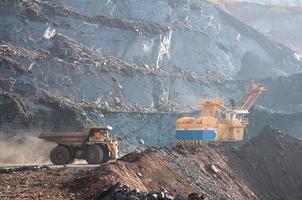 Los camiones volquete de mina a cielo abierto conducen solo zona industrial de la cantera de mineral de hierro foto