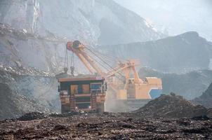 open cast mine dump trucks drive alone industrial area of iron ore quarry photo