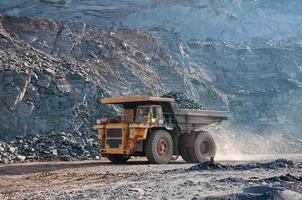 open cast mine dump trucks drive alone industrial area of iron ore quarry photo