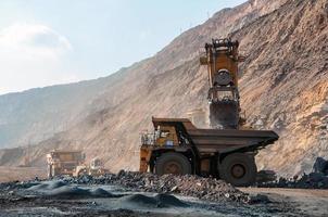 open cast mine dump trucks drive alone industrial area of iron ore quarry photo