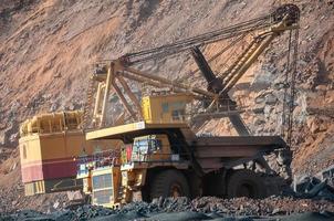 open cast mine dump trucks drive alone industrial area of iron ore quarry photo