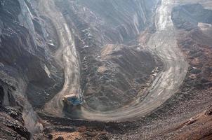 open cast mine dump trucks drive alone industrial area of iron ore quarry photo