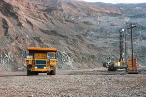 open cast mine dump trucks drive alone industrial area of iron ore quarry photo