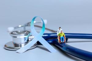 Man sitting on wheelchair and doctor with ribbons , World cancer day concept photo