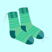 a pair of knitted warm striped turquoise socks with protruding threads on a blue background vector