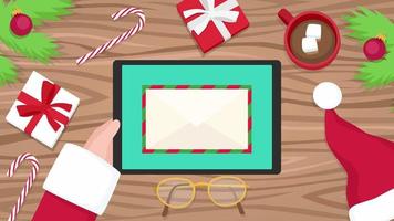 de kerstman houdt tablet vast en opent e-mail video