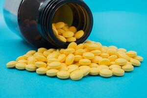 Medical pills spilling out of a toppled from pill bottle photo