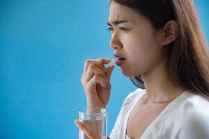 Young woman taking medicine pill after doctor order photo