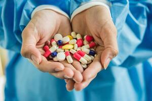 La mano de la mujer vierte las píldoras medicinales de la botella. foto