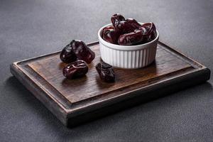 Beautiful delicious dates on a dark concrete background photo
