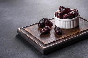 Beautiful delicious dates on a dark concrete background photo