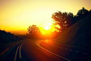 sunset orange in the road track beautiful Road turning in the hills and Mountain road grassland road in the evening in. photo