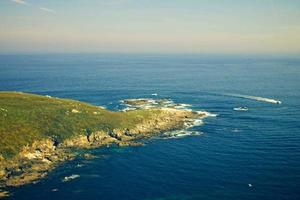 verde y azul mar y azul cielo hermoso mar y puesta de sol con gran sol amarillo bajo las colinas de la superficie del mar en el fondo. foto