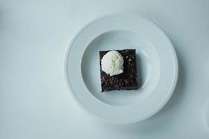slice of brownie and ice cream on plate on table