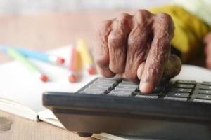 senior women hand using calculator on desk photo