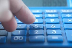 Close up of man hand using calculator photo