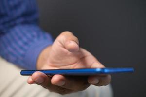 Close up of young man hand using smart phone. photo