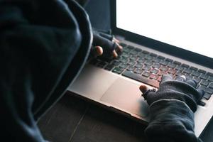 hacker hand stealing data from laptop top down photo