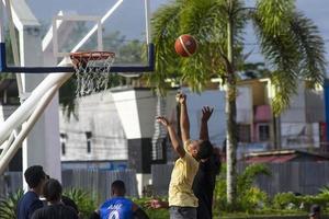 Sorong, West Papua, Indonesia, November 28th 2021. The activities at Aimas town square in Sunday morning. People playing basketball photo
