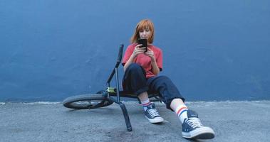 Young woman posing with BMX bicycle outdoor on the street photo