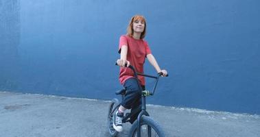 Mujer joven posando con bicicleta BMX al aire libre en la calle foto