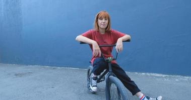Mujer joven posando con bicicleta BMX al aire libre en la calle foto