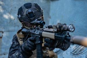 modern soldier in black multicam uniform with rifle, urban background photo