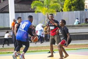 sorong, papua occidental, indonesia, 28 de noviembre de 2021. las actividades en la plaza de aimas el domingo por la mañana. gente jugando baloncesto foto