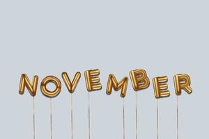 november written with foil gold balloons. november lettering with realistic gold balloons. november typography. isolated vector design. november background with copy space area