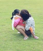 Mother and daughter happily play on the green lawn photo