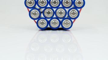 Lots of AA and AAA alkaline batteries on a white background. Ecological recycling concept. The terminals of the disposable batteries are close together and form a beautiful backdrop. Energy source. photo