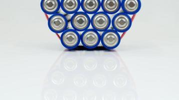 Lots of AA and AAA alkaline batteries on a white background. Ecological recycling concept. The terminals of the disposable batteries are close together and form a beautiful backdrop. Energy source. photo