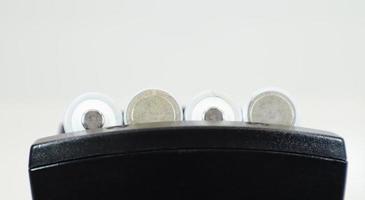 Fast charging of AA batteries. Rechargeable batteries in a black charger with four battery cells on a white background. photo