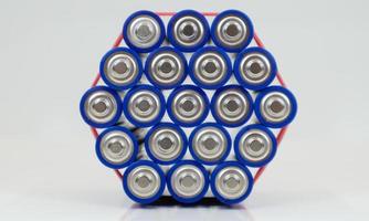 Lots of AA and AAA alkaline batteries on a white background. Ecological recycling concept. The terminals of the disposable batteries are close together and form a beautiful backdrop. Energy source. photo