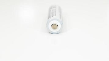 One alkaline battery on a white background with reflection. Energy supply and recycling concept. Copy space. Minimalism. Eliment AA is the most common type of galvanic batteries and accumulators. photo