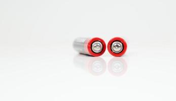 Two type AAA alkaline rechargeable batteries on white glossy background with reflection with copy space. Ukraine, Kiev - January 7, 2021. photo