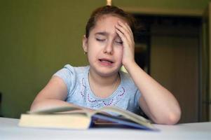 child reading a book at the table photo