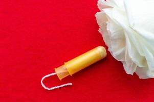 women's tampons with a rose flower on a blue background. The concept of women's health.