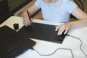 child draws on a graphic tablet photo