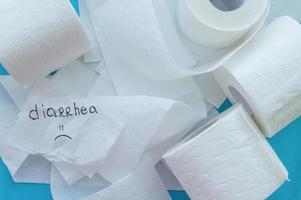 rollos de papel higiénico blanco etiquetados como diarrea sobre un fondo azul. de cerca. foto