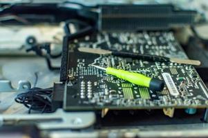 a man repairs a computer, solders a board, repairs electronics and modern technologies photo