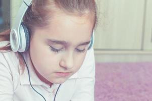 girl listening to music on headphones in the room photo