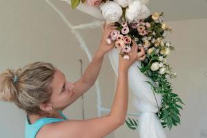 girl makes wedding, festive arch of flowers photo